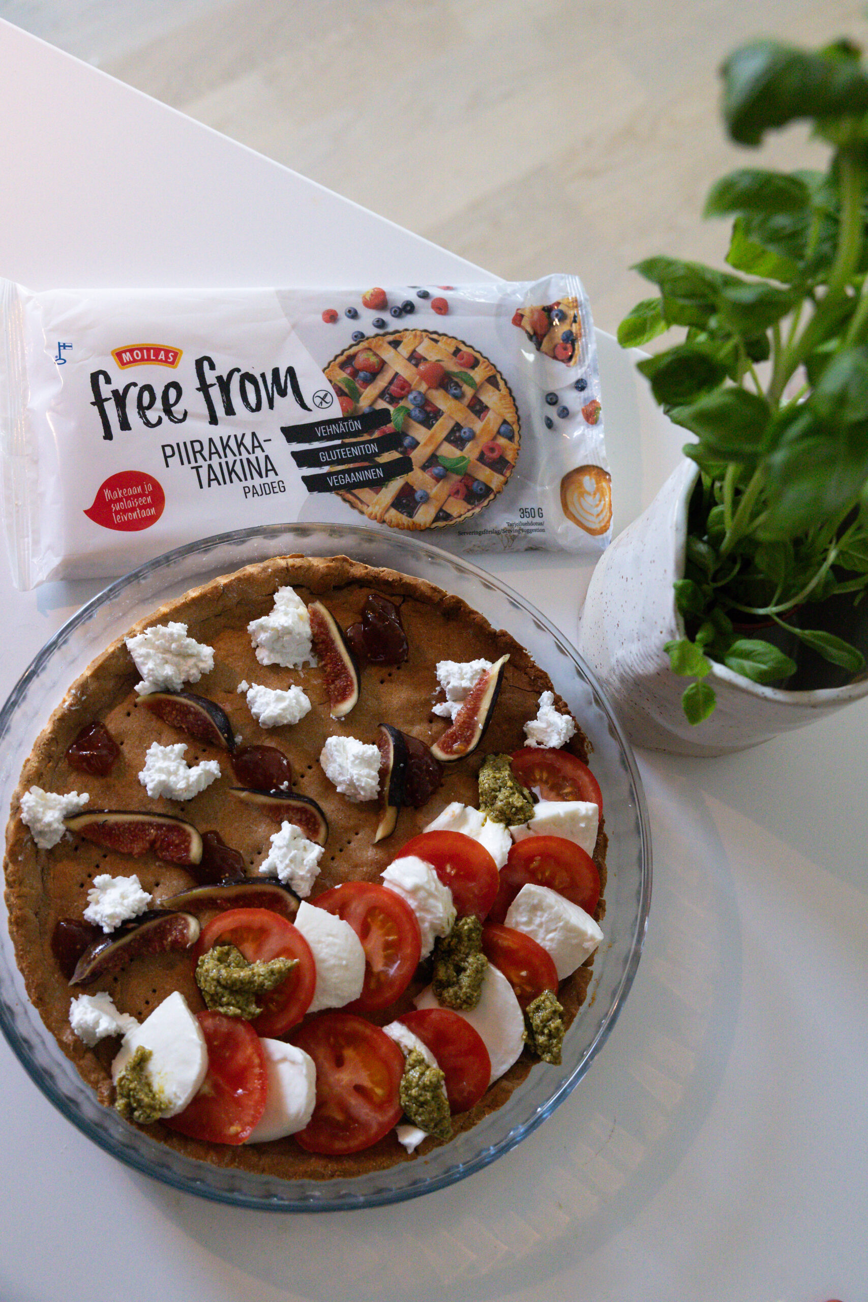 Tekovaihekuva Moilas Free From Piirakkataikinasta tehtävästä suolaisesta puolipiirakasta. Kuvassa täytteet levitetty ennen muna-kermaviili-sekoituksen kaatamista niiden päälle. 